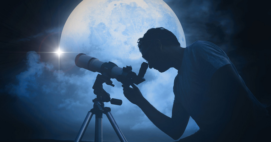 Man looking at the moon through a telescope