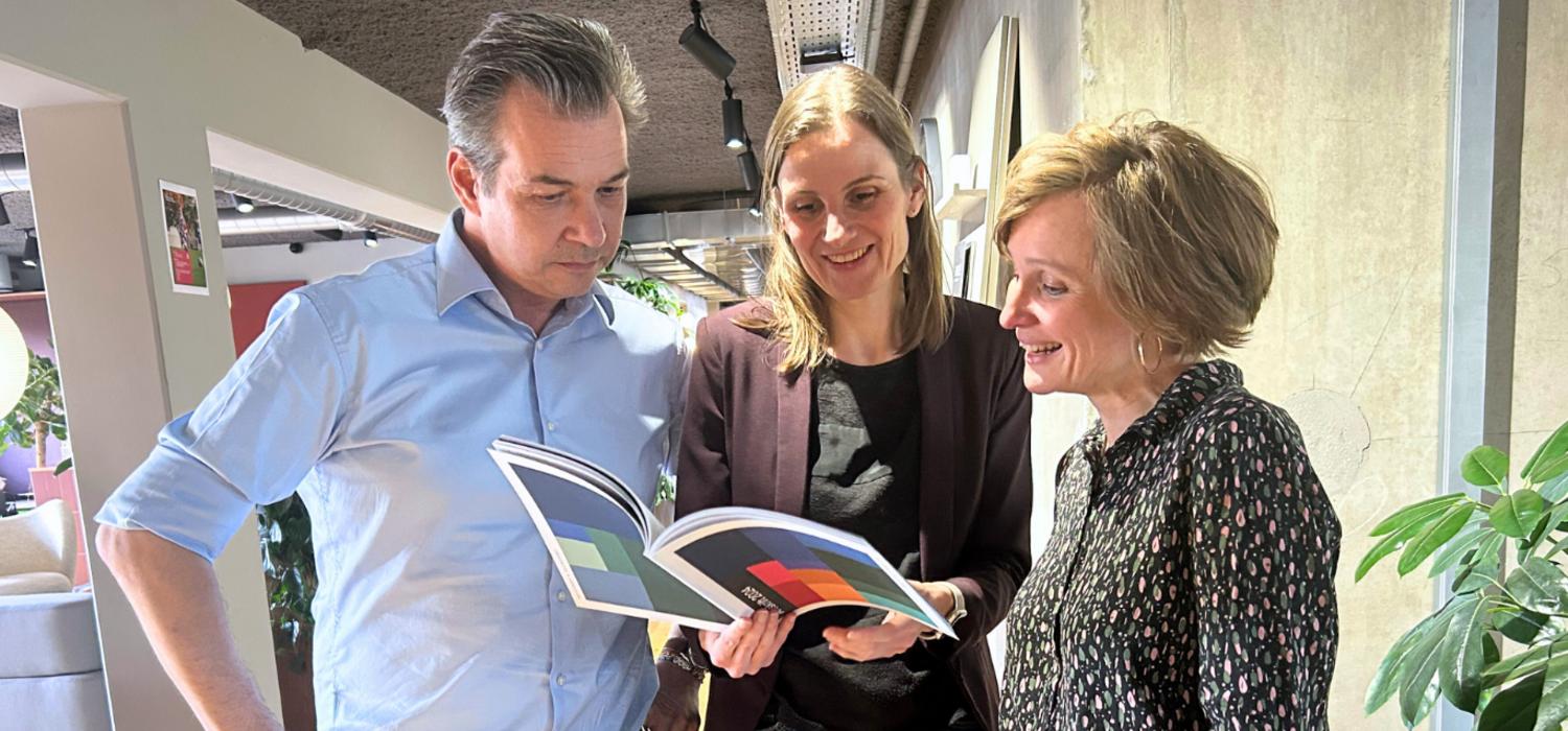 Two men and a woman looking at document