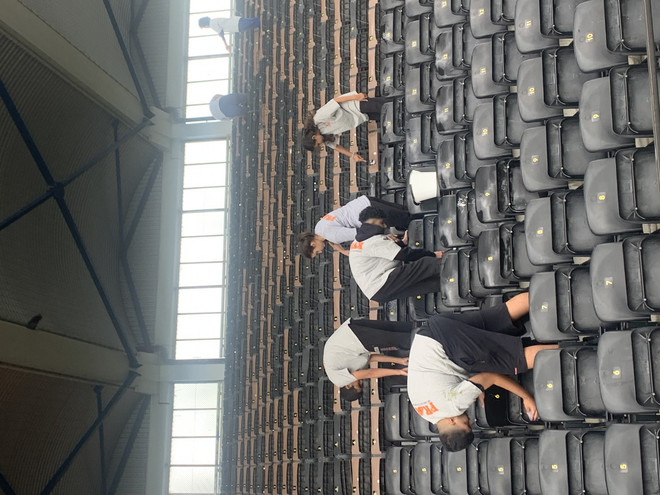 Young people from Fritidsakademiet are cleaning the stands.